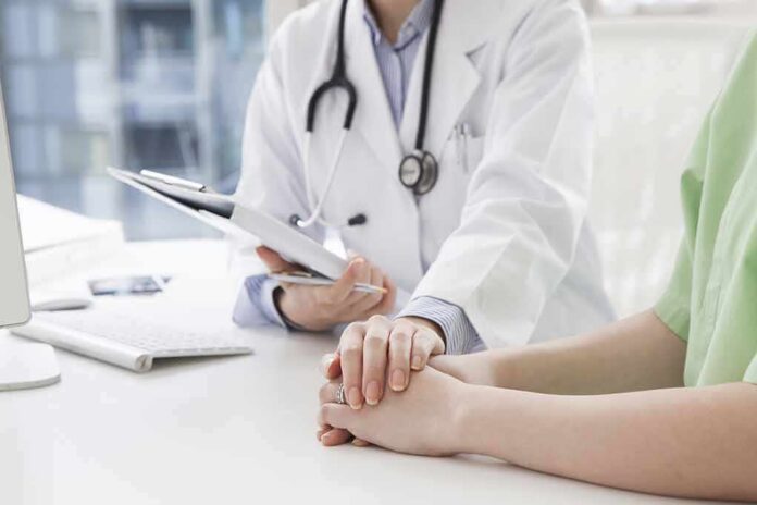 shutterstock_266789537 Doctor holding a patient's hands during consultation