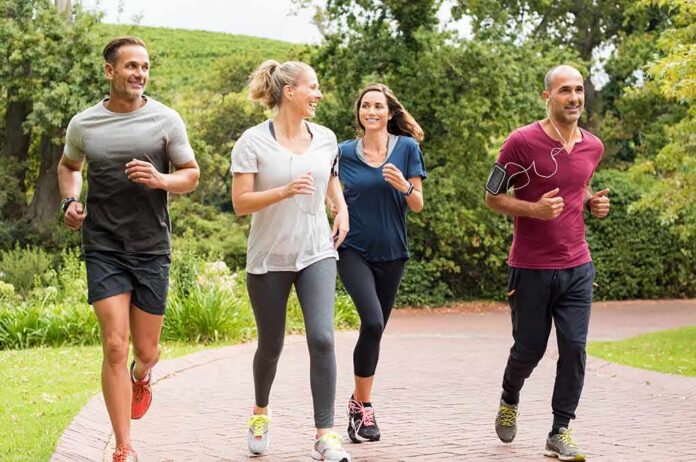 shutterstock_613868252 Group of adults jogging together in a park