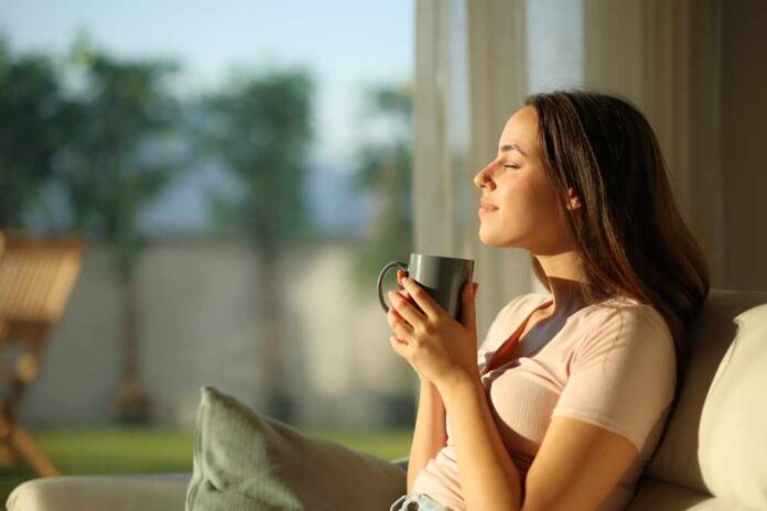 Side,View,Profile,Of,A,Relaxed,Woman,Smelling,Coffee,Sitting Woman enjoying a cup of coffee in a sunlit room