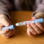 Arthritis Relief Linked to Surprising Weight-Loss Drug Hands holding an Ozempic injection pen.