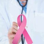 Doctor holding stethoscope with pink ribbon in front