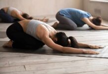 Restorative Yoga for Reducing Anxiety and Burnout Group of people in child's pose during a yoga class