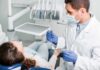Dentist examining patient in dental chair