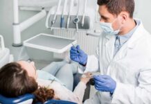Dentist examining patient in dental chair