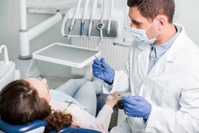 Dentist examining patient in dental chair