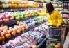Woman in a yellow coat shopping for fruits in a supermarket