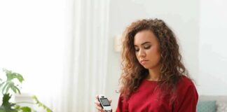 Woman using a blood glucose meter at home