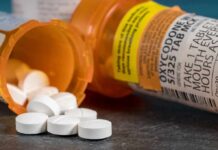 white pills spilling from prescription bottles