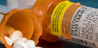white pills spilling from prescription bottles