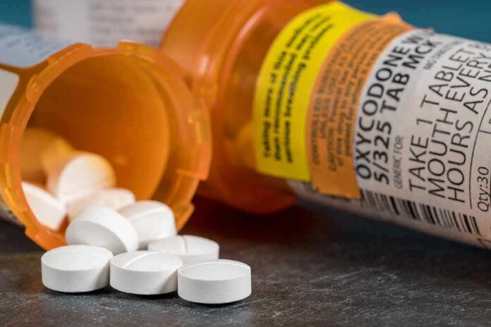 shutterstock_1360335023 white pills spilling from prescription bottles