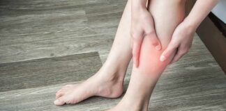 person holding calf with red area indicating leg pain