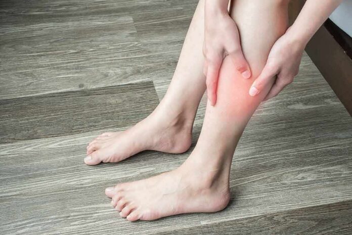 person holding calf with red area indicating leg pain