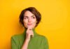 The Science Behind Gut Feelings woman in green turtleneck thinking against yellow background