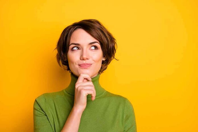 shutterstock_1617540484 woman in green turtleneck thinking against yellow background