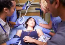 Patient on hospital gurney surrounded by medical staff