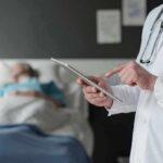 Mayo Clinic’s RADICAL Cancer Playbook Revealed Doctor using tablet beside hospital patient