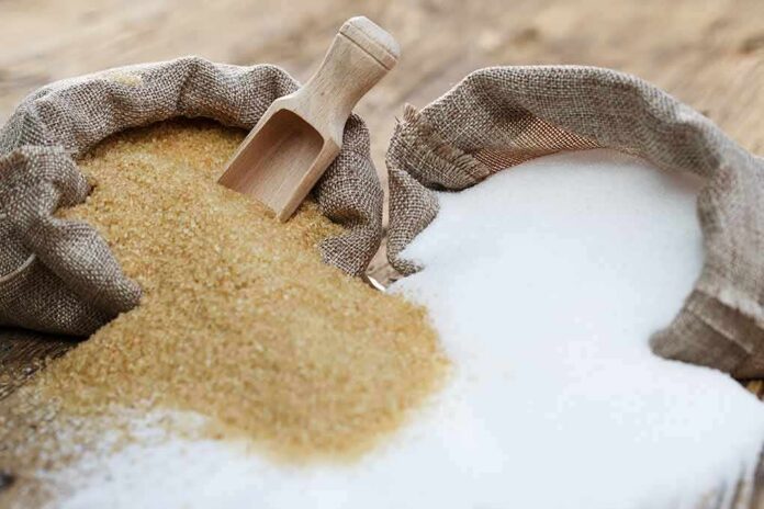 Brown and white sugar in burlap sacks with wooden scoop