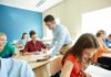 Teen Literacy COLLAPSE Tied To Screens Teacher assisting students in a classroom