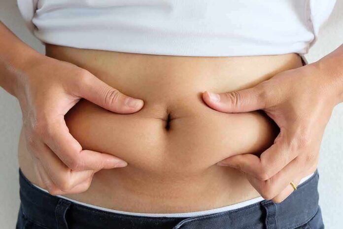 shutterstock_510854272-1 person pinching belly fat at the waist