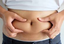 Belly Fat Tied To Embarrassing Leaks person pinching belly fat at the waist