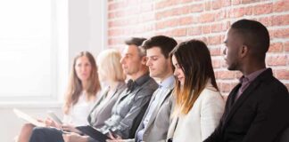 Job applicants seated in a row with clipboards