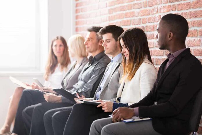 Job applicants seated in a row with clipboards