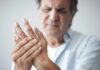 Man holding his hand in discomfort