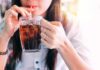 Beer And Soda Linked To Gout Spike person sipping iced drink from a glass mug with a straw
