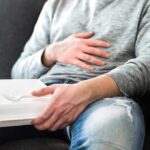 Bloating Trap: The Fiber Mistake Everyone Makes Person holding takeout container while touching stomach