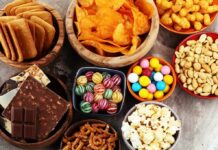 Surprising Contaminants in Your Kid’s Favorite Snacks Assorted snacks in bowls including chips, candies, nuts, popcorn, and chocolate