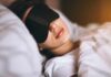 ‘What in the World’ – Is sleepmaxxing actually helpful? Woman sleeping with a black eye mask in bed