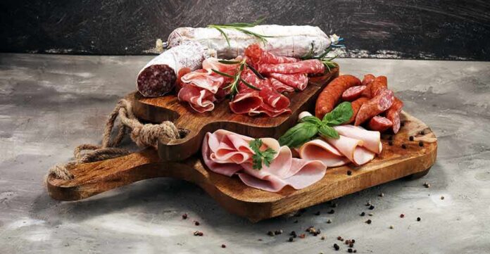 Charcuterie board with assorted cured meats and herbs