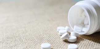 White tablets spilling from a plastic bottle