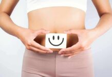 Gut Hack That Lowers Cholesterol and Inflammation torso of person holding smiley card over stomach