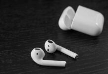 Ozlo Sleepbuds 2 Review – These Will Help You Sleep Better Wireless earbuds with open charging case on dark wood