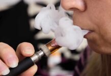 Close-up of a person vaping, exhaling smoke clouds