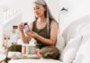Creatine Myth-Buster: Gains Without the Bloat Woman reading supplement bottle label on a sofa