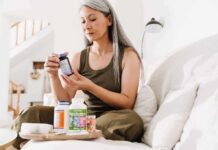 Creatine Myth-Buster: Gains Without the Bloat Woman reading supplement bottle label on a sofa