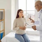 Doctor talking with patient in a clinic exam room