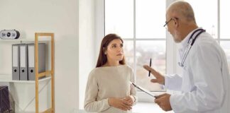 Doctor talking with patient in a clinic exam room