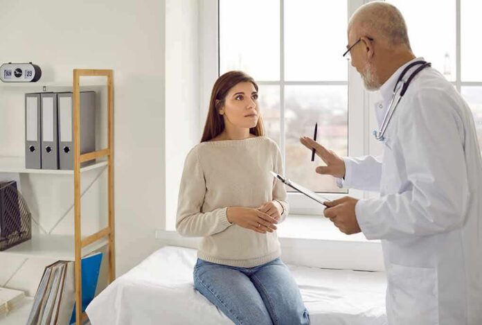 Doctor talking with patient in a clinic exam room
