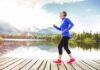 Older woman jogging on a wooden dock by a mountain lake