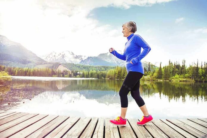Older woman jogging on a wooden dock by a mountain lake