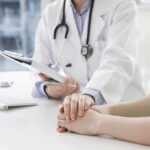 Silent Epidemic Slams Women With Double Hit Doctor holding a patient's hands during consultation
