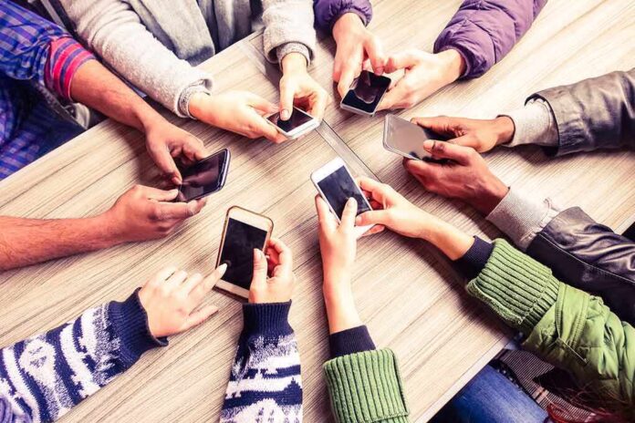 Hands around a table holding smartphones