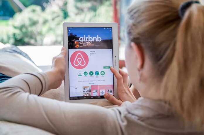 Woman using a tablet to view the Airbnb app page