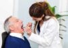 Mouth Bacteria, Mind Slide? Dentist examining an older man's mouth with a dental mirror